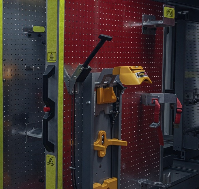 Vertical peg-board tool wall with clamps and irons in a fire locker